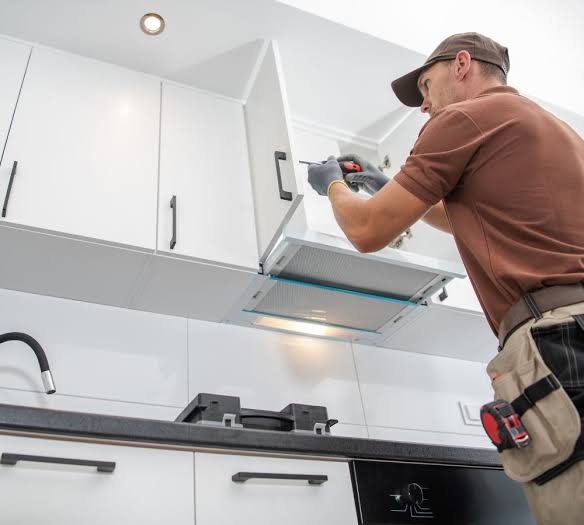 Homeowner inspecting outdated kitchen cabinets while planning a kitchen renovation in the GTA.